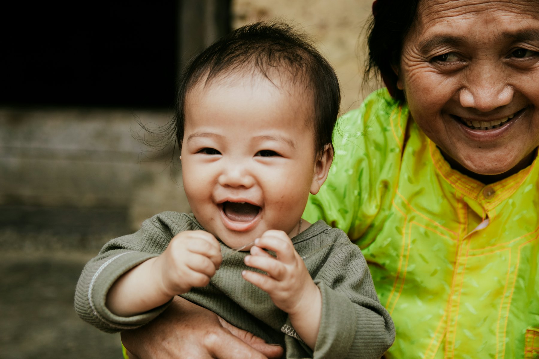 Grandmother holding her laughing baby grandchild
