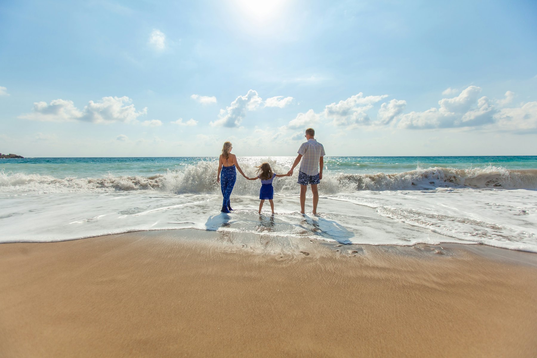 Family walking hand in hand along the beach