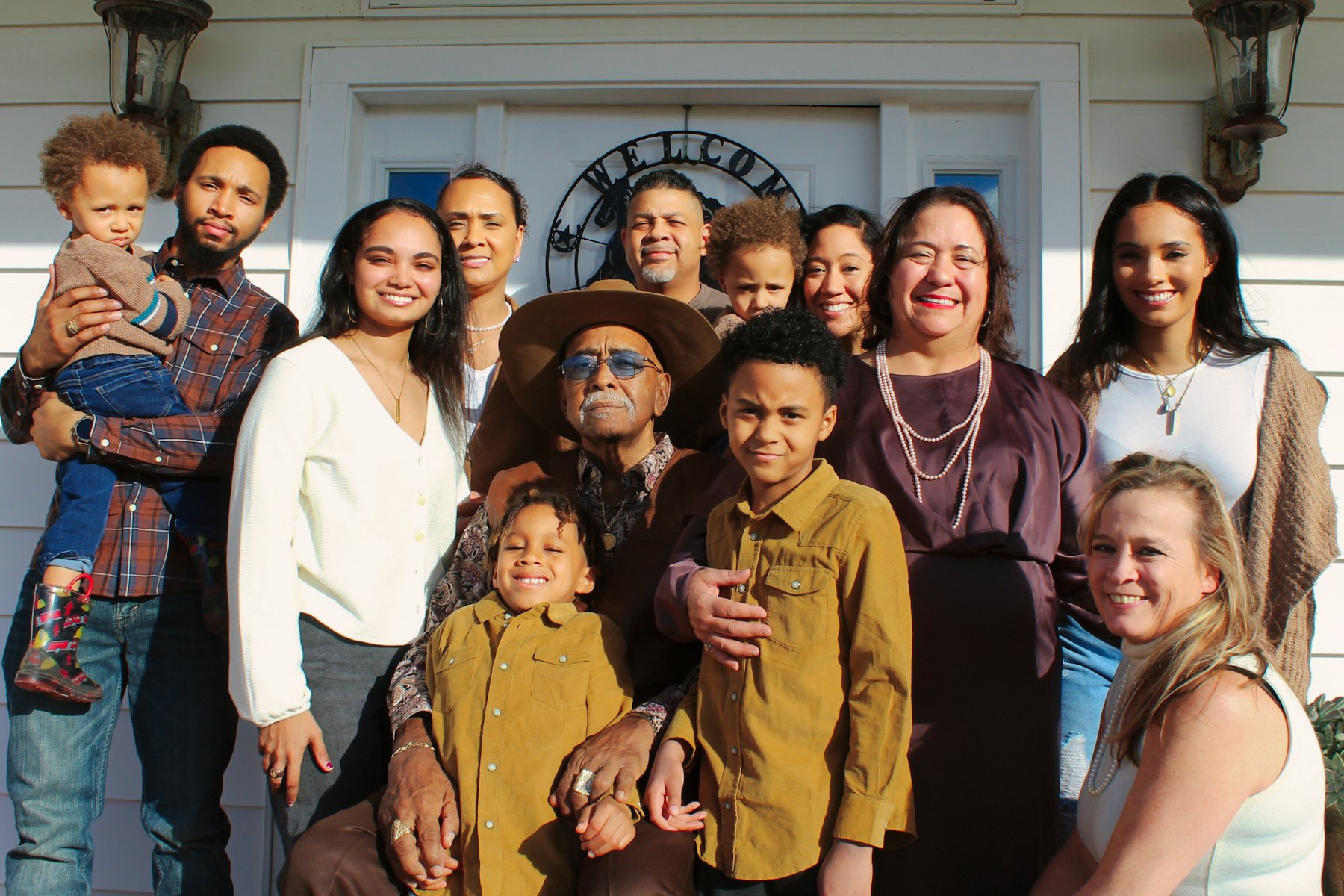 Large extended family posing together outside their home