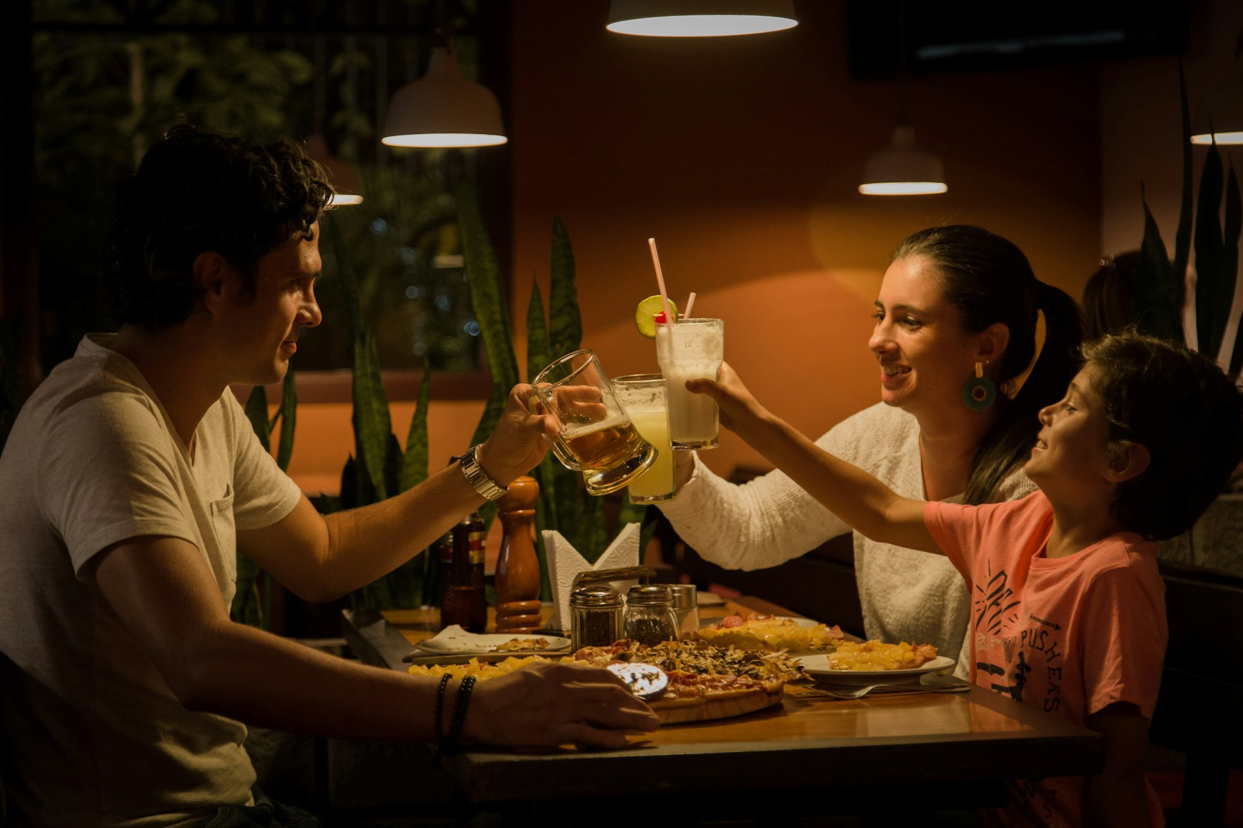 Family raising a toast together over a warm dinner