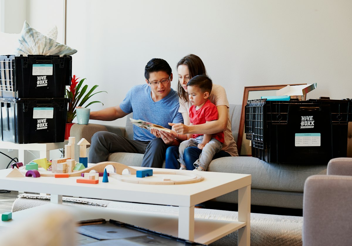 Parents reading with their young children on the sofa