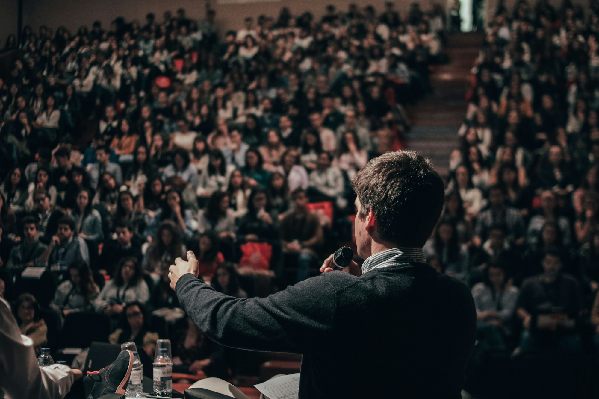 Speaker addressing a large audience at a talk