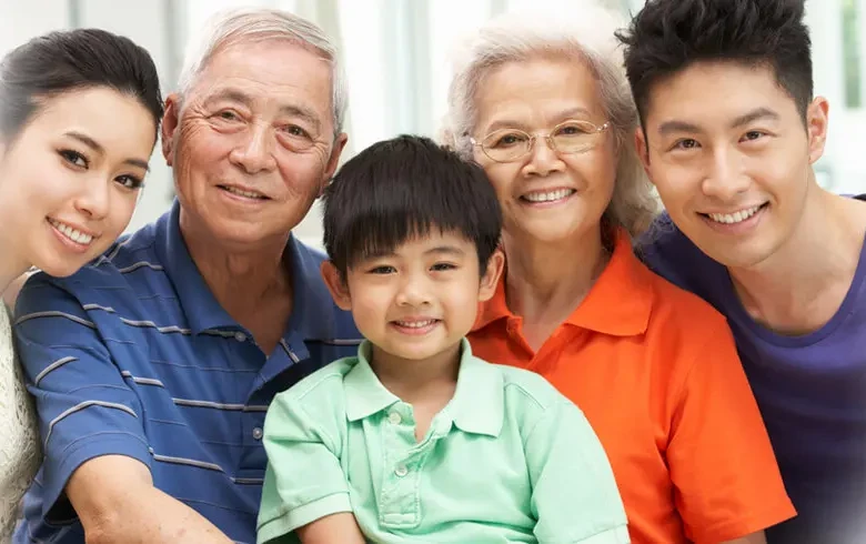 Three generations of a Malaysian family smiling together